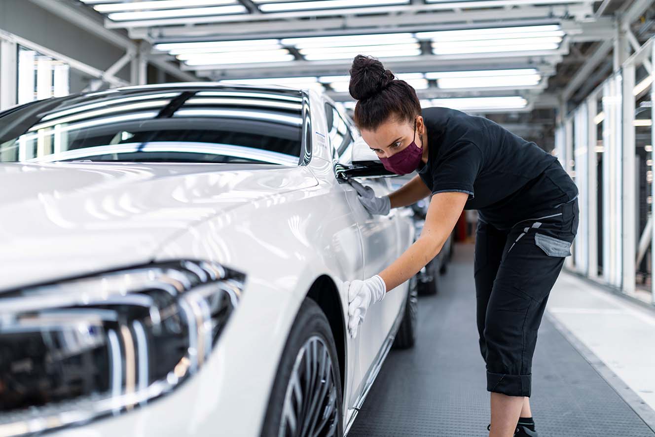 Produktionsmitarbeiterin kontrolliert fabrikneues Fahrzeug